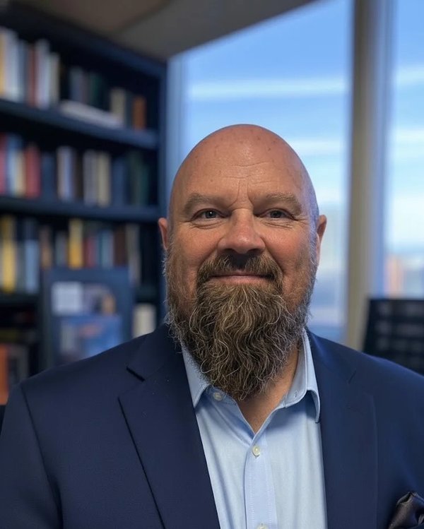Randy A. Bridge, author of Hard Hat Philosophy — a bearded man in a navy jacket and light blue shirt, photographed in front of a bookshelf.